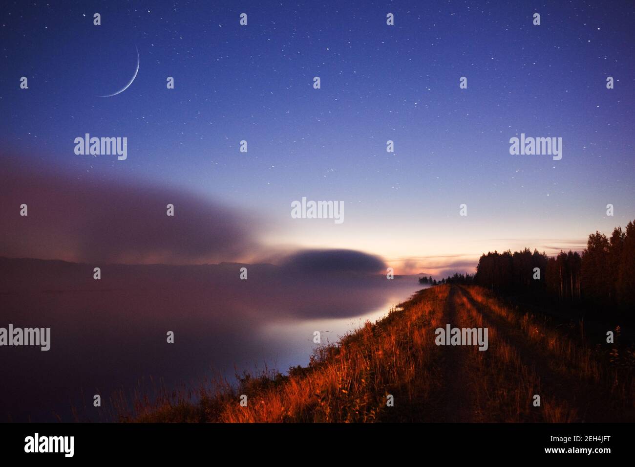 Luna di Crescent di cera sopra il paesaggio del fiume nebby. Foto Stock Luna di Crescent di cera sopra il paesaggio del fiume nebby. Foto Stock