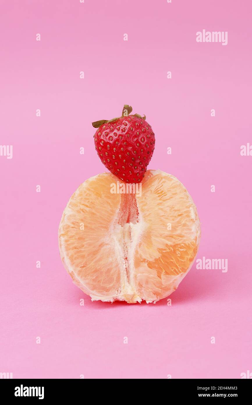 arancio e fragola su sfondo rosa Foto Stock
