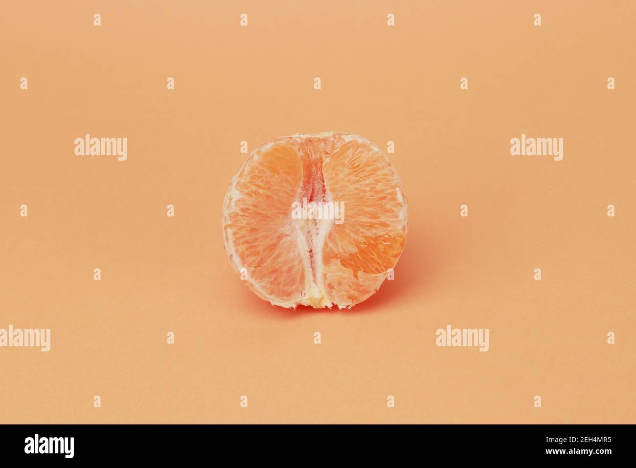 frutta arancione senza pelle su uno sfondo di colore della pelle Foto Stock