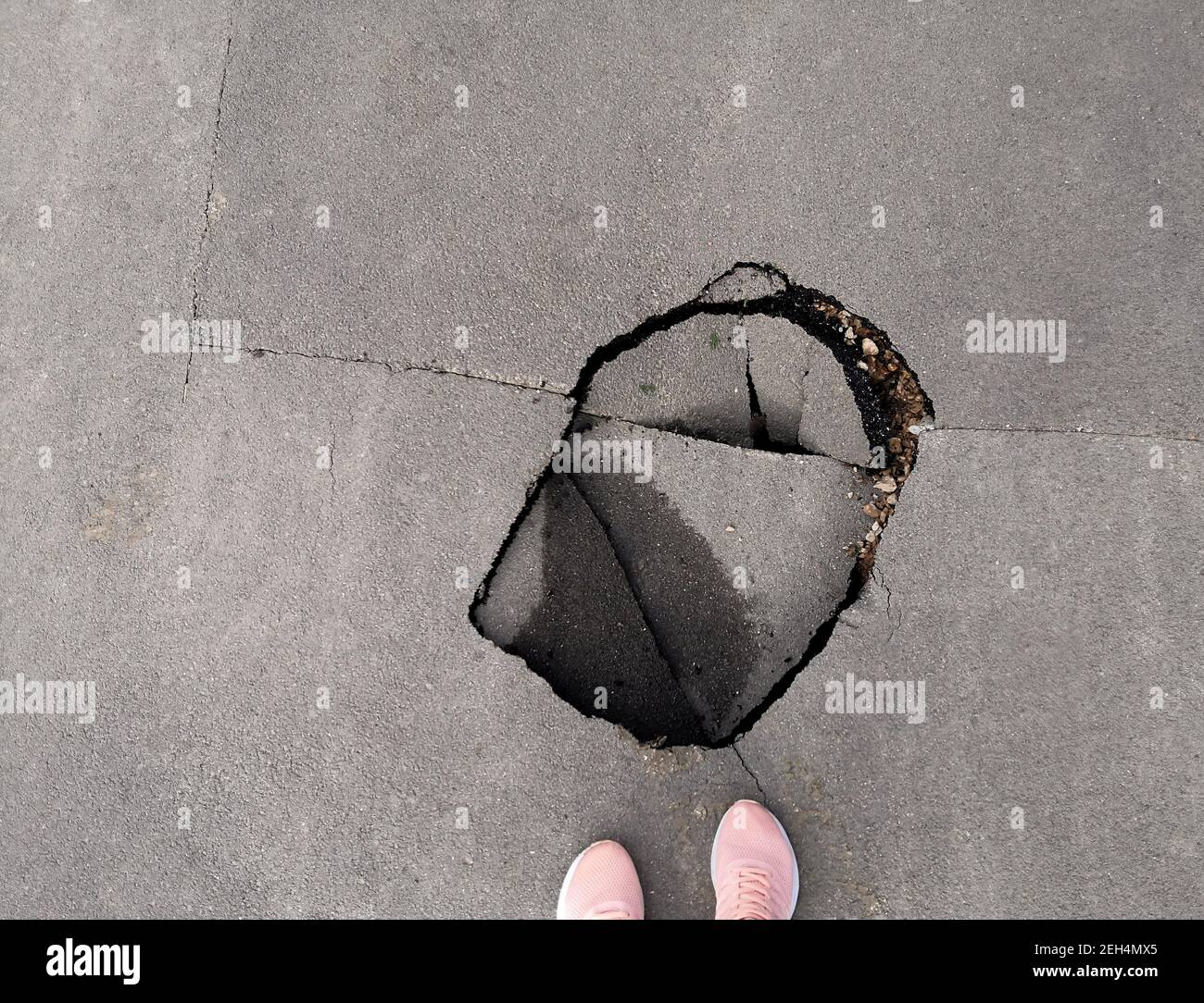 Un buco nella strada. Buca nell'asfalto. Strada rotta. Strada asfaltata danneggiata Foto Stock