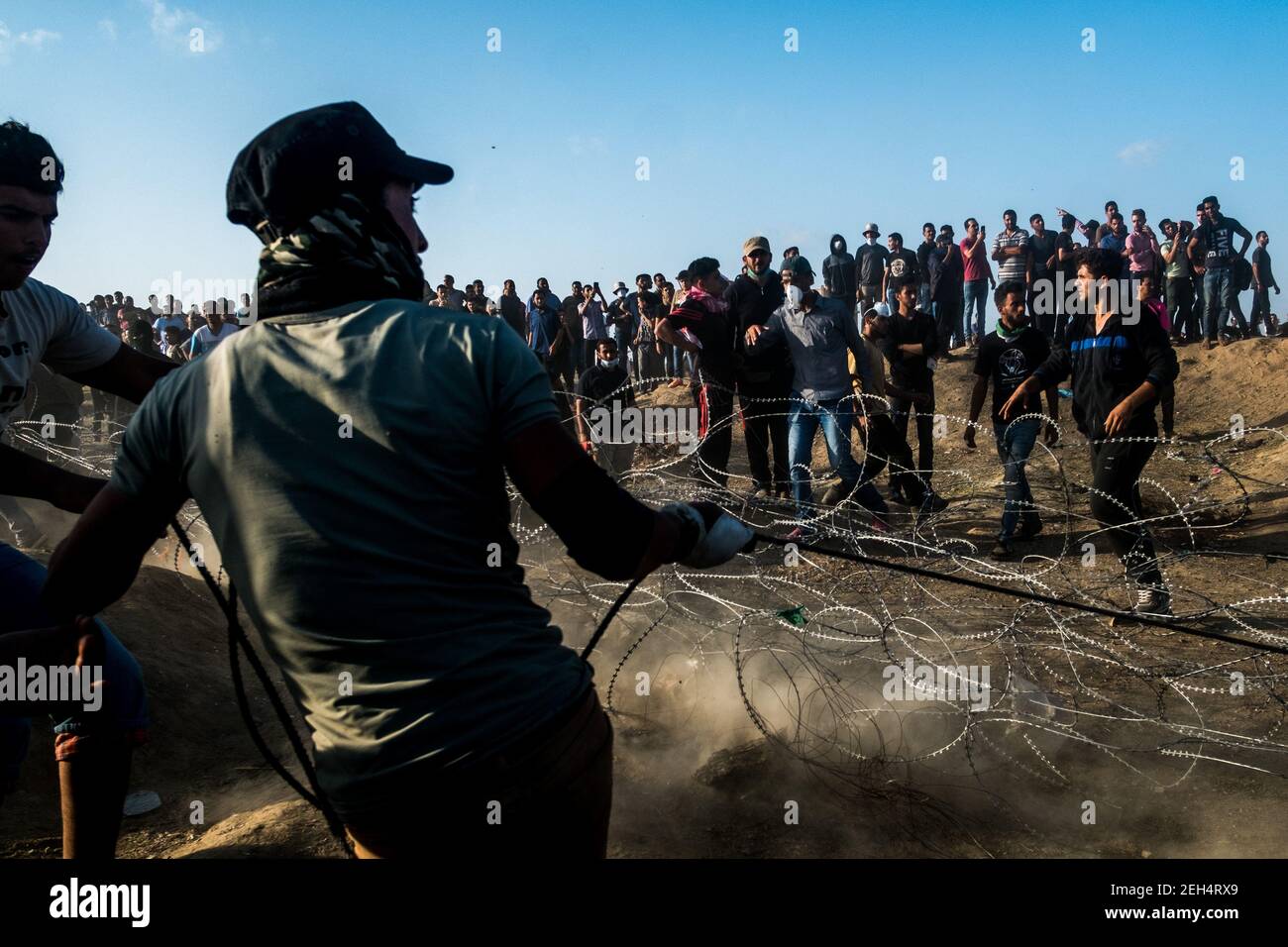 I manifestanti corrono con filo spinato che hanno strappato al confine israeliano. Le tensioni sono elevate lungo il confine tra Gaza e Israele dopo più di un mese di proteste di massa settimanali vicino alla barriera che ha lasciato 50 dimostranti palestinesi morti e più di 1,700 feriti da un incendio israeliano. I leader di Hamas a Gaza hanno promesso che le marce continueranno fino alla revoca del blocco decennale israeliano del territorio. Le proteste sono previste anche il 14 e 15 maggio, il giorno in cui i palestinesi celebreranno Yawm An-Nakba o 'giorno del disastro' per commemorare l'anniversario della loro deracinazione di massa d Foto Stock
