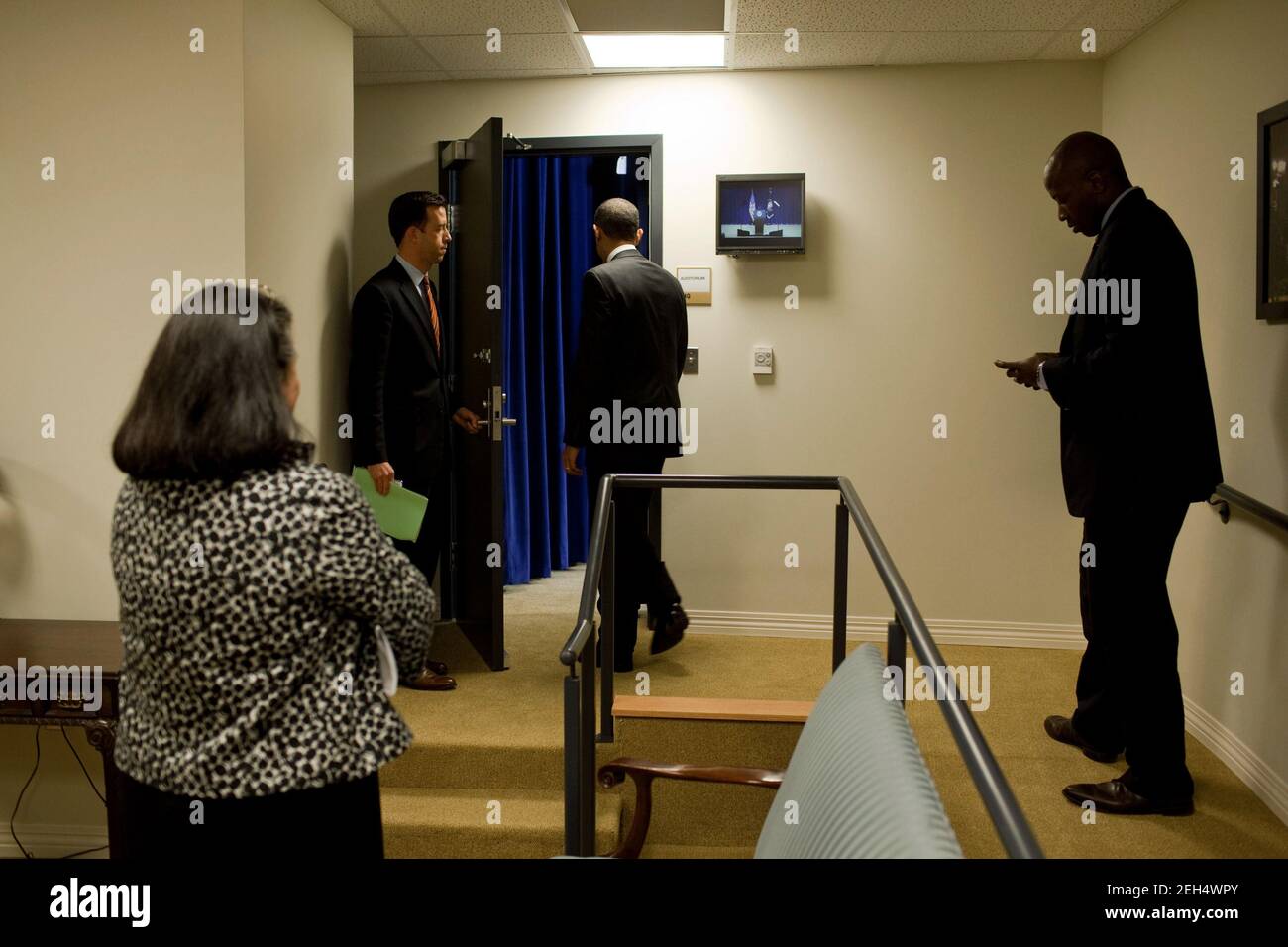 Vice Direttore di Oval Office Operations Brian Mosteller detiene la porta per il Presidente Barack Obama mentre si prepara a consegnare osservazioni ai membri della Camera di Commercio degli Stati Uniti, Federazione Nazionale di Independent Business (NFIB), E proprietari di piccole imprese per quanto riguarda la riforma dell'assicurazione sanitaria, nella Corte Sud del Eisenhower Executive Office Building, 29 ottobre 2009. Personale Aide Reggie Love e direttore dell'Ufficio di impegno pubblico Tina Tchen stand vicino. Foto Stock