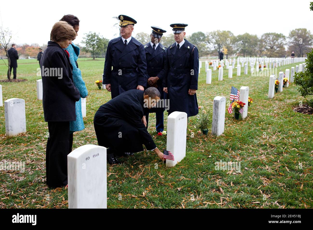 Il presidente Barack Obama lascia una moneta presidenziale al gravesite del vincitore della Medaglia d'onore di 19 anni, lo Specialista Ross McGinnis, che è uno dei due destinatari della Medaglia d'onore commemorati al Cimitero di Arlington dalle guerre in Iraq e Afghanistan. Il presidente si trovava al Cimitero di Arlington per dare le osservazioni del giorno dei Veterani, il 11 novembre 2009. Foto Stock
