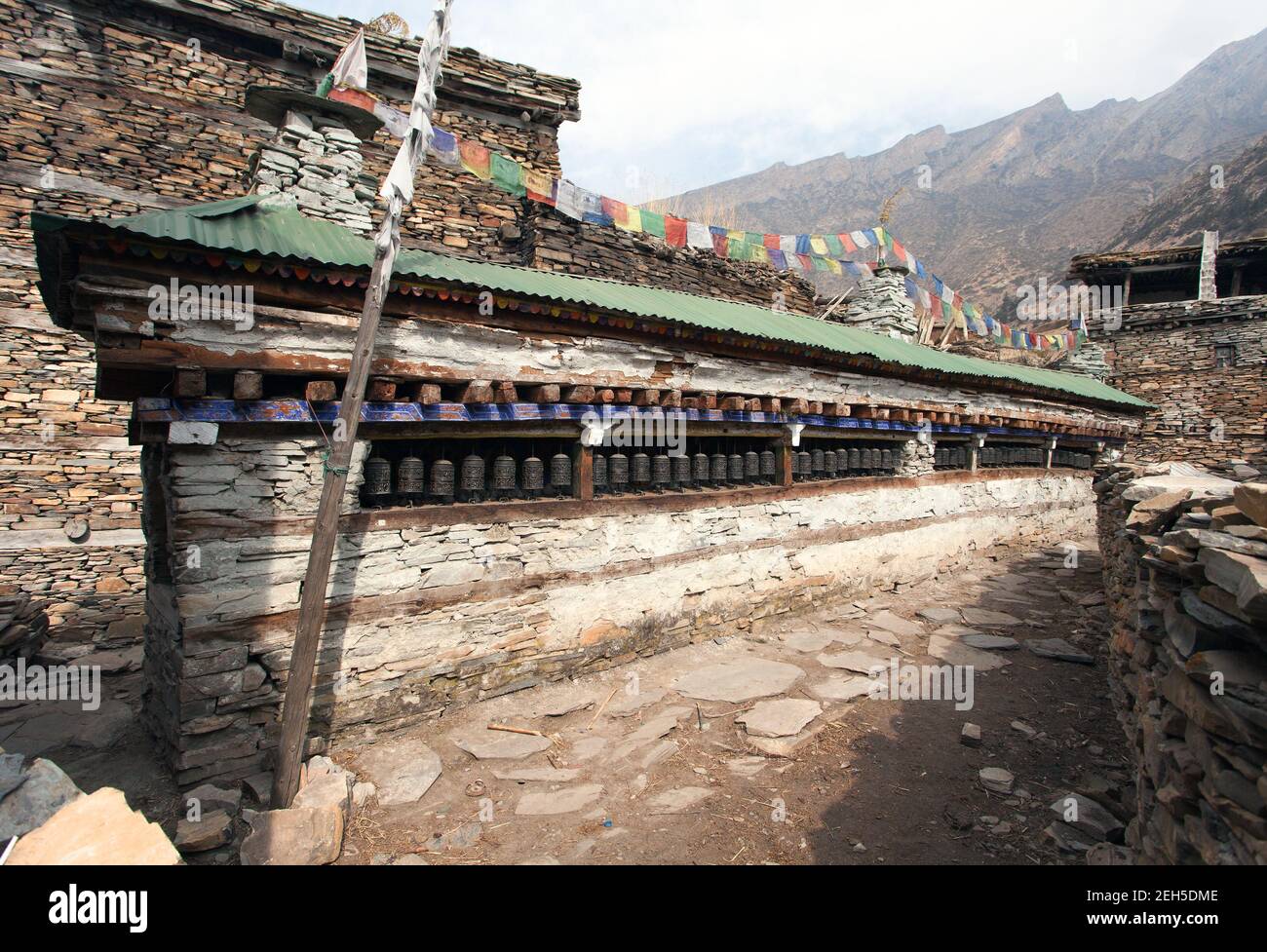 Preghiera buddista molti muri con ruote di preghiera nel villaggio nepalese, percorso di trekking circuito Annapurna, Nepal Foto Stock