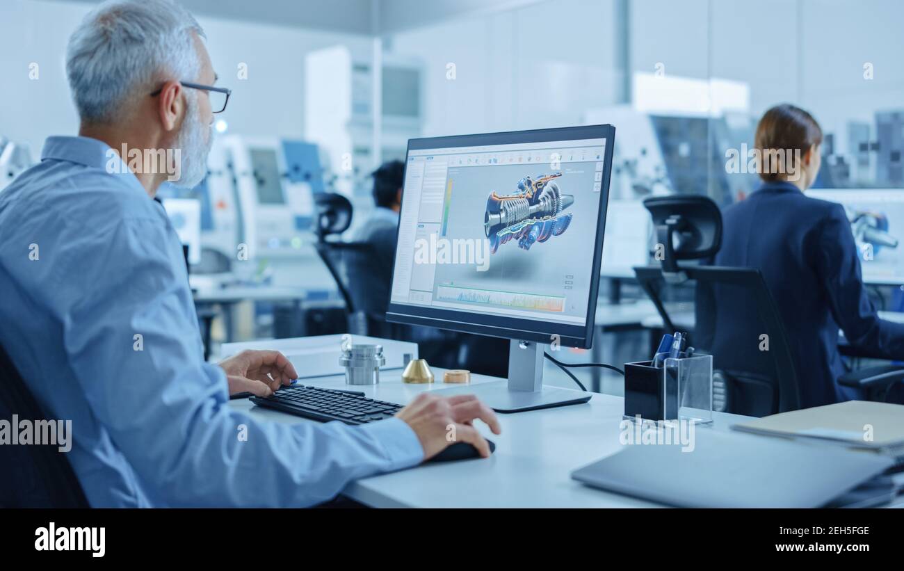 Fabbrica industriale moderna: Team di ingegneri meccanici che lavorano sui computer, utilizzando i più recenti dispositivi high-tech come le cuffie per la realtà virtuale per la progettazione Foto Stock