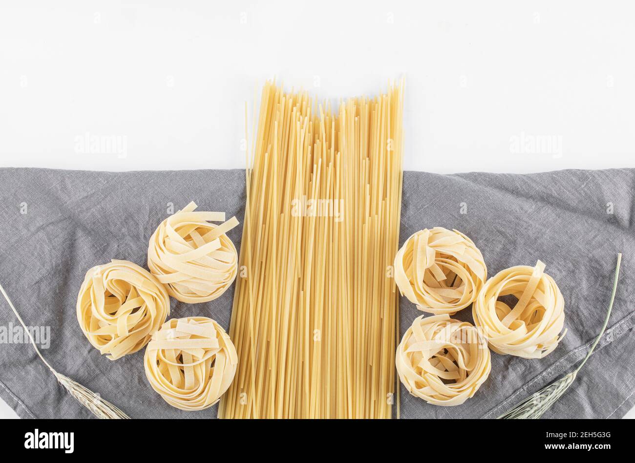 Varietà di pasta cruda su tovaglia grigia Foto Stock