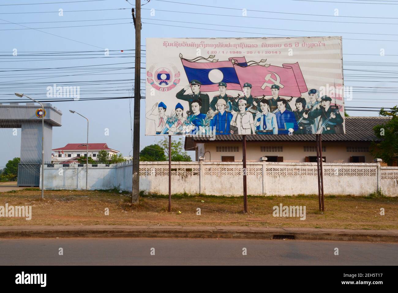 Thak HEK, Laos - Aprile 2015: Grandi striscioni con disegno di propaganda comunista con bandiere e persone lungo la strada Foto Stock