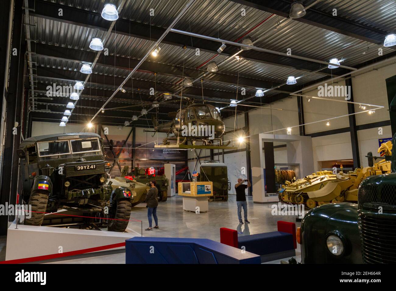 I visitatori si trovano accanto ai veicoli esposti al REME Museum (Royal Electrical and Mechanical Engineers), Lyneham, Wiltshire, Regno Unito. Foto Stock