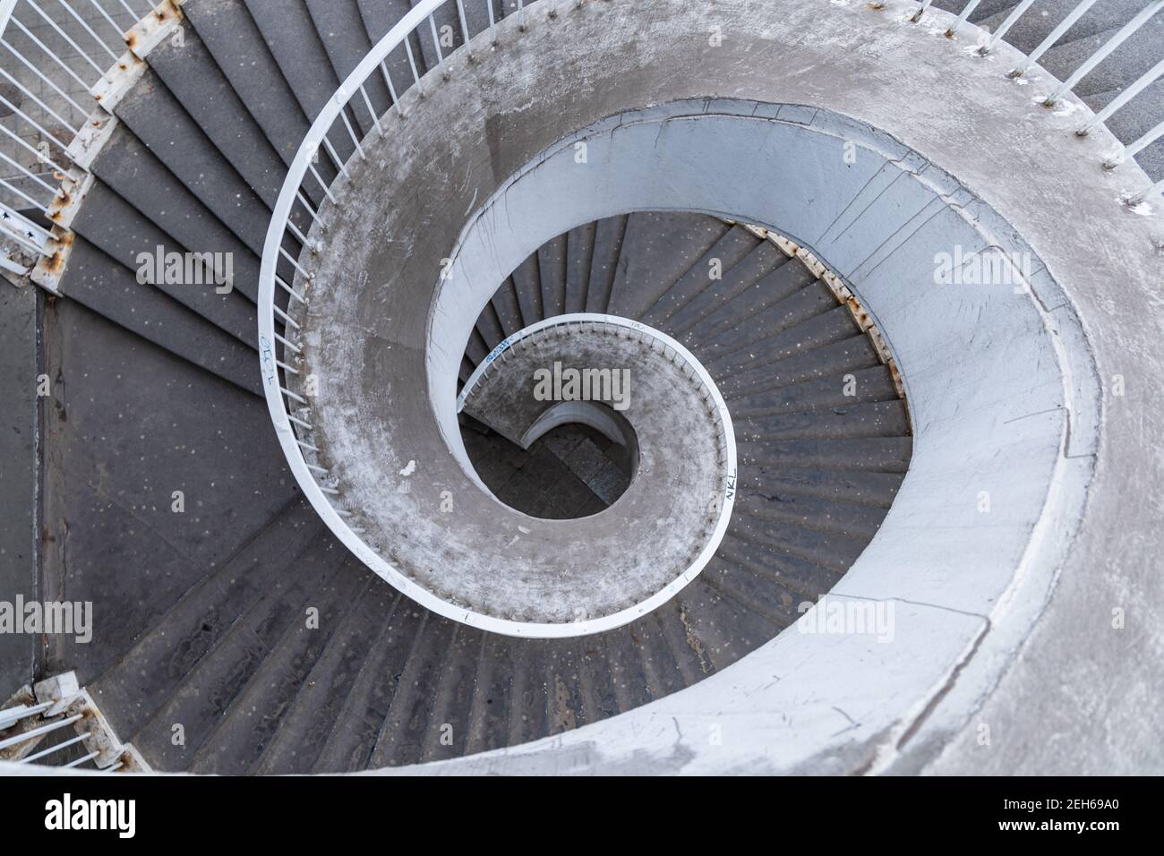 Vecchia scala a chiocciola in cemento all'aperto con ringhiere in metallo arrugginito Foto Stock