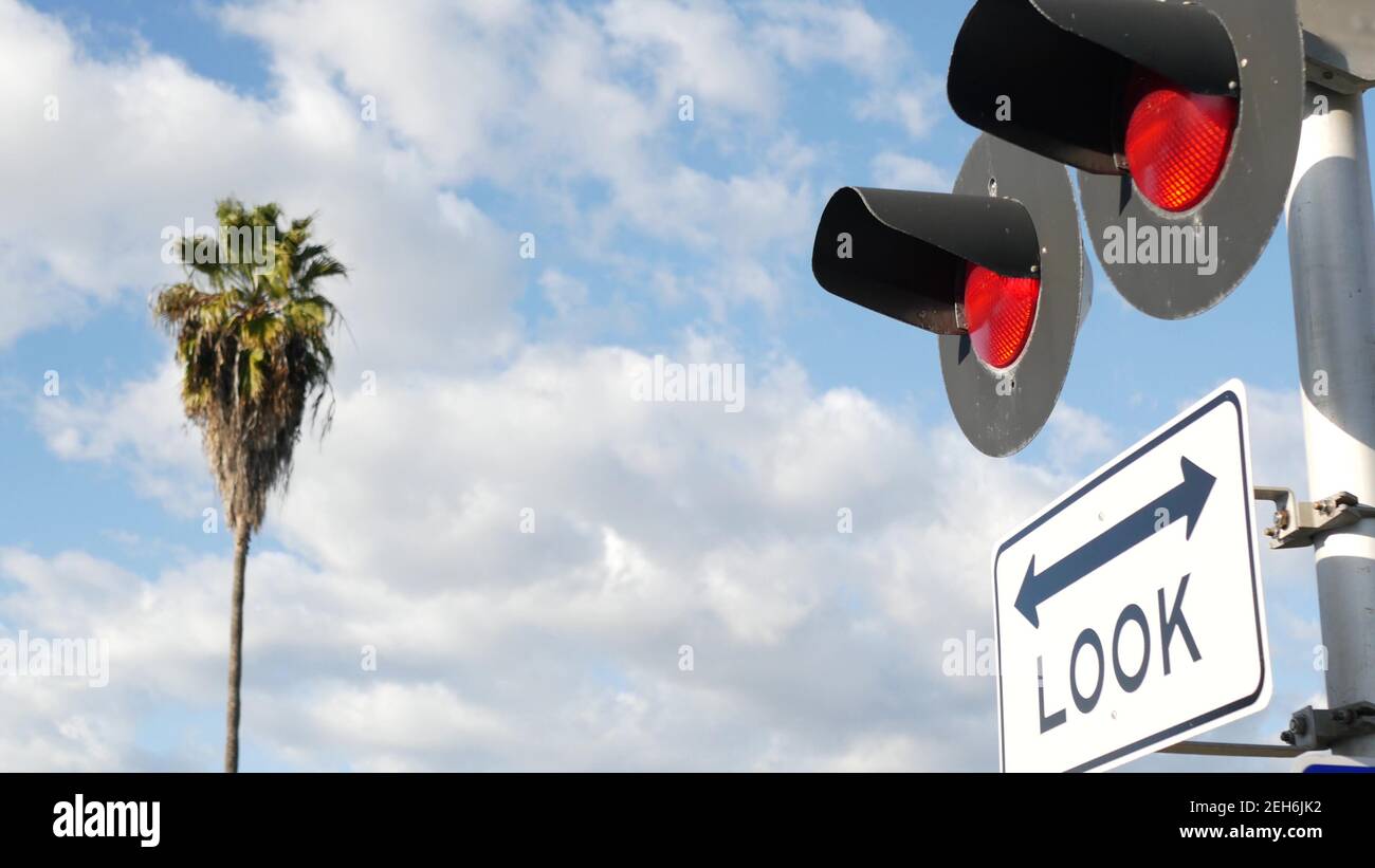 Segnale di avvertimento di attraversamento del livello negli Stati Uniti. Avviso Crossbuck e semaforo rosso all'incrocio ferroviario in California. Sicurezza del trasporto ferroviario Foto Stock