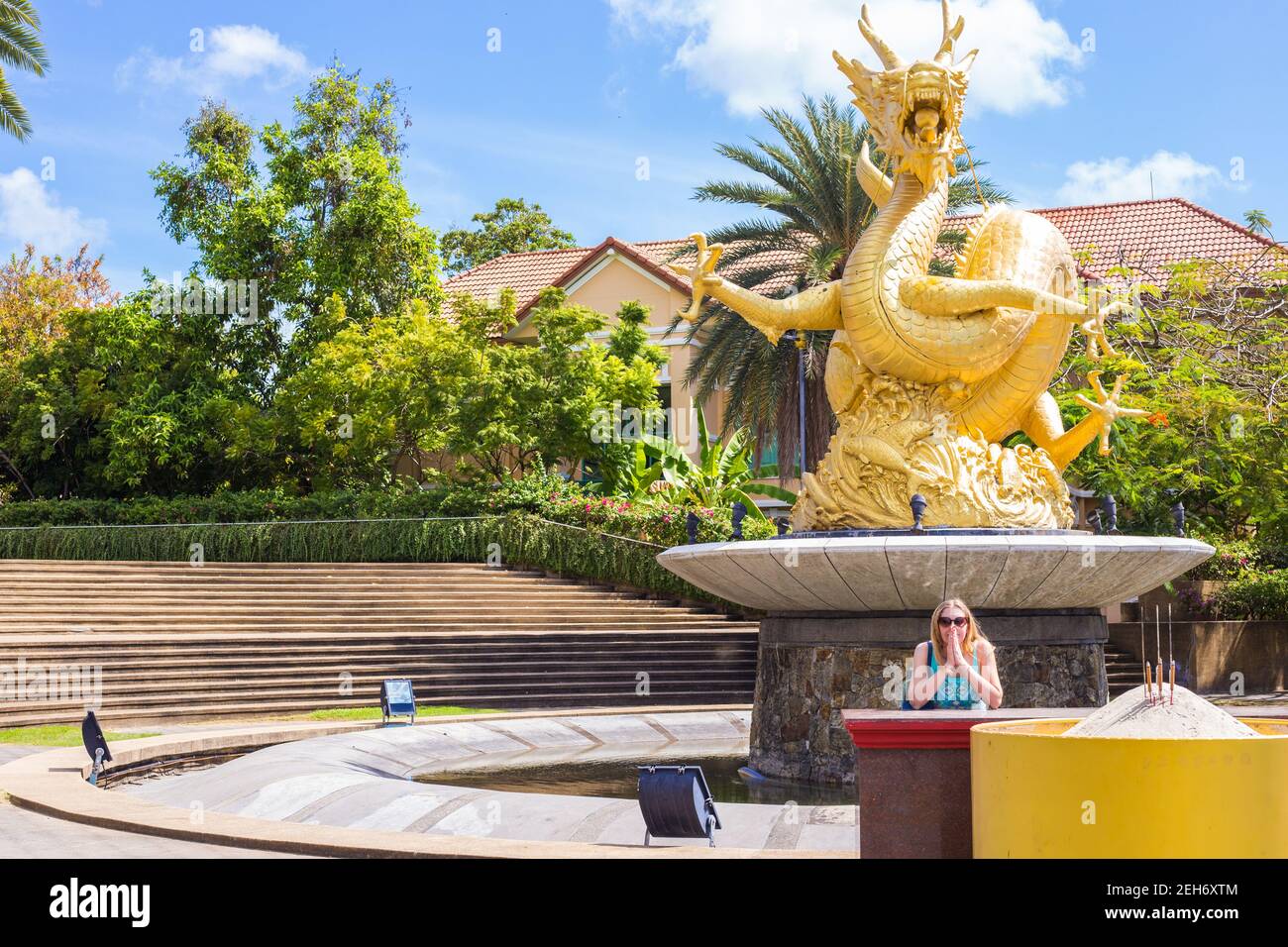 Golden Dragon nel Sirikit Park, Thailandia sull'isola di Phuket. La donna alla statua le ha piegate le mani in una barca. Viaggi e turismo in Asia. Foto Stock