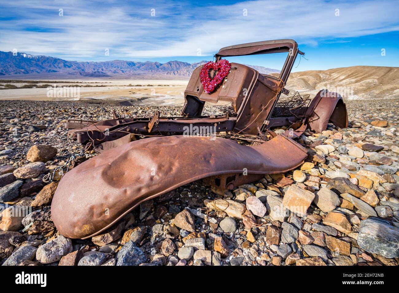 Corpo arrugginito di vecchia macchina abbandonata con corona di San Valentino attaccato nel Parco Nazionale della Valle della morte, California. Offerta Valentine Card Foto Stock