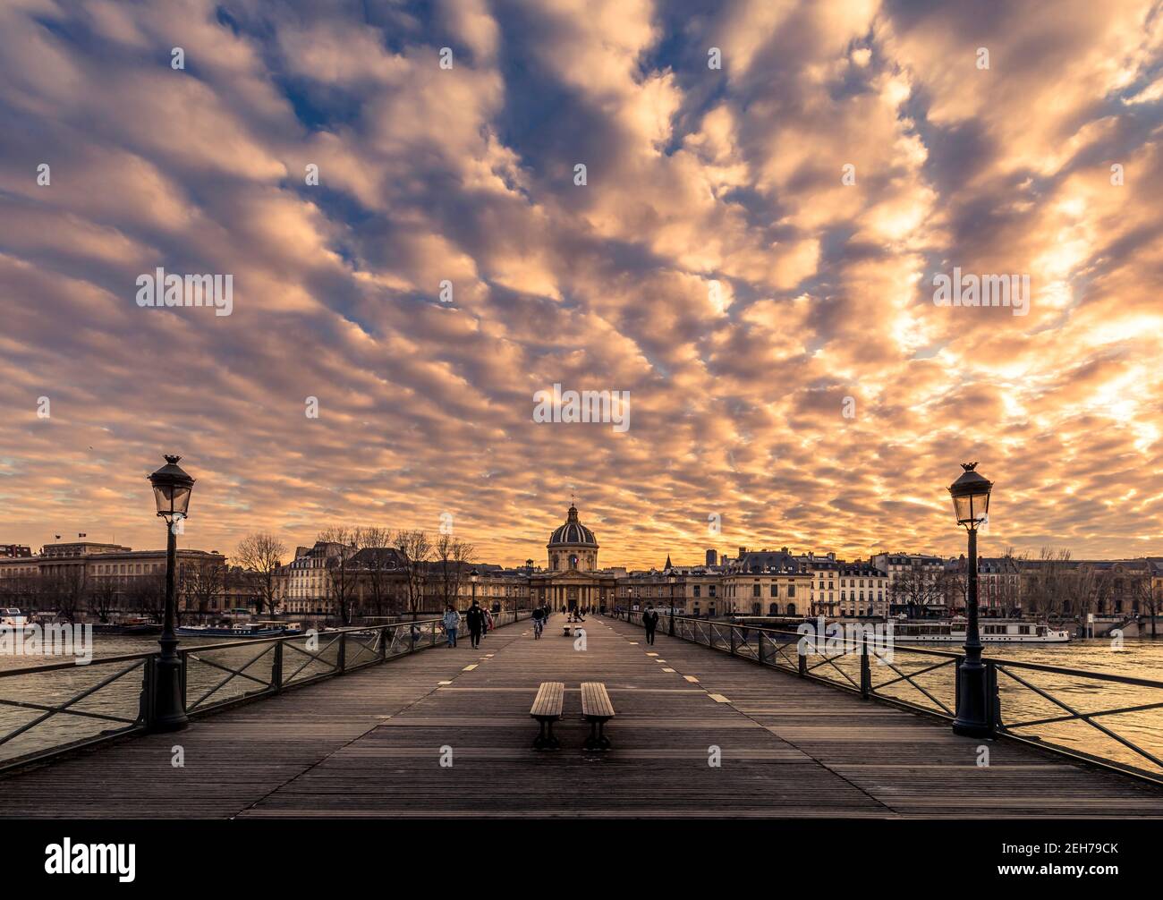 Parigi, Francia - 12 febbraio 2021: Panca di legno di Parigi sul ponte di legno Pont des Arts al tramonto Foto Stock