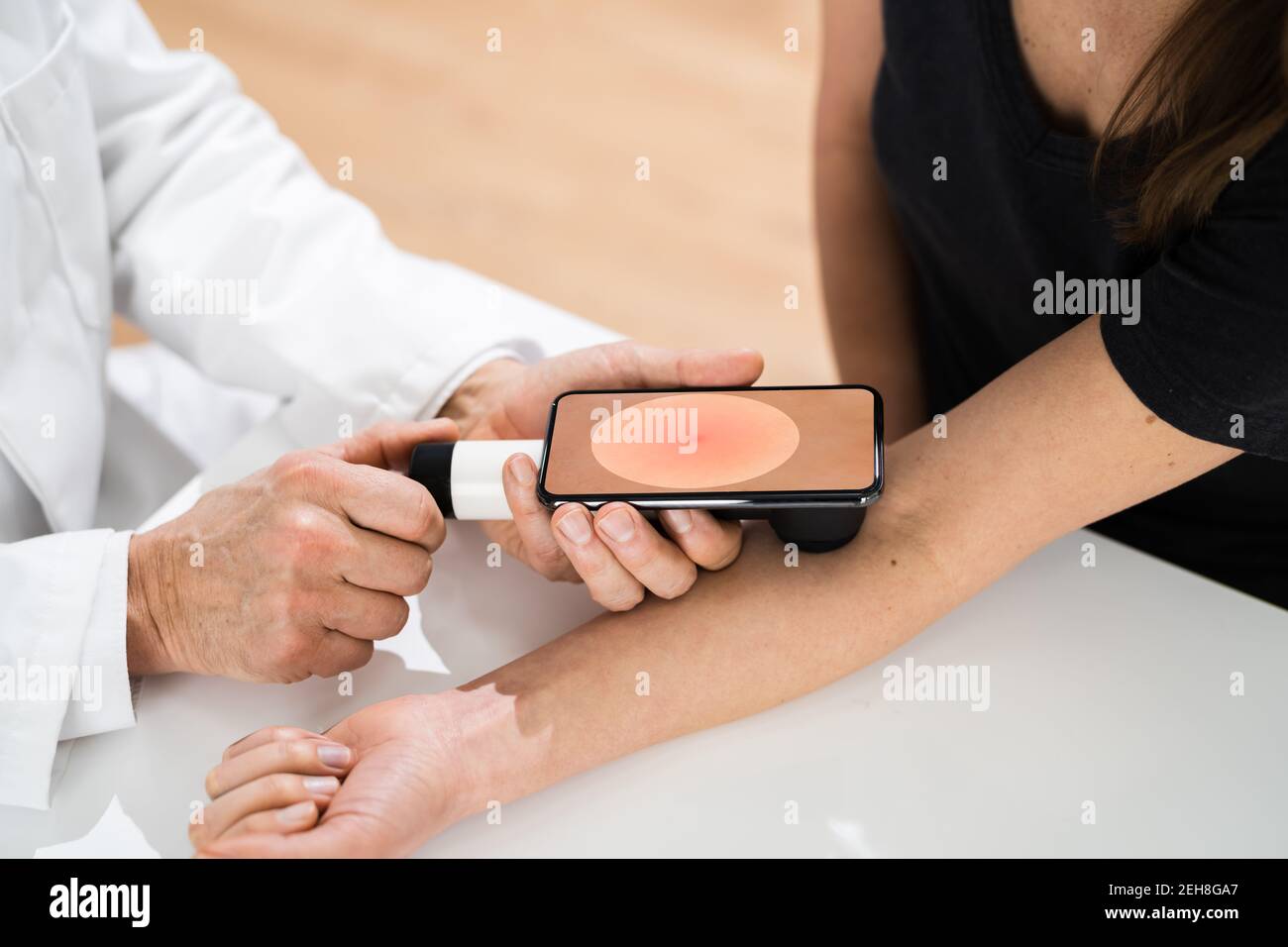 Medico che esamina la pelle pigmentata della donna del paziente Foto Stock