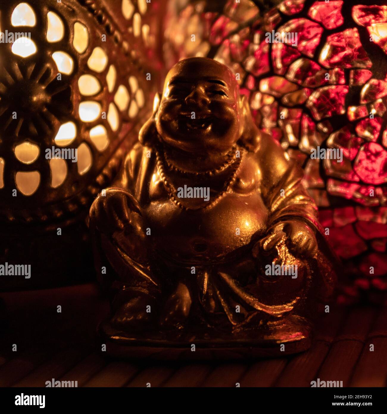 Monaco dorato illuminato da candele ornamentali. Meditazione e consapevolezza Foto Stock