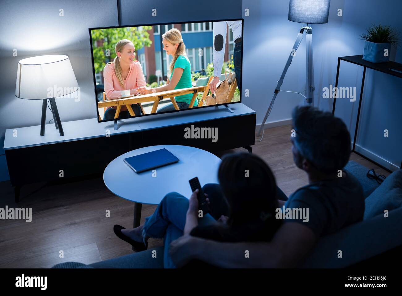 Coppia che guarda il film TV sul divano di notte Foto Stock