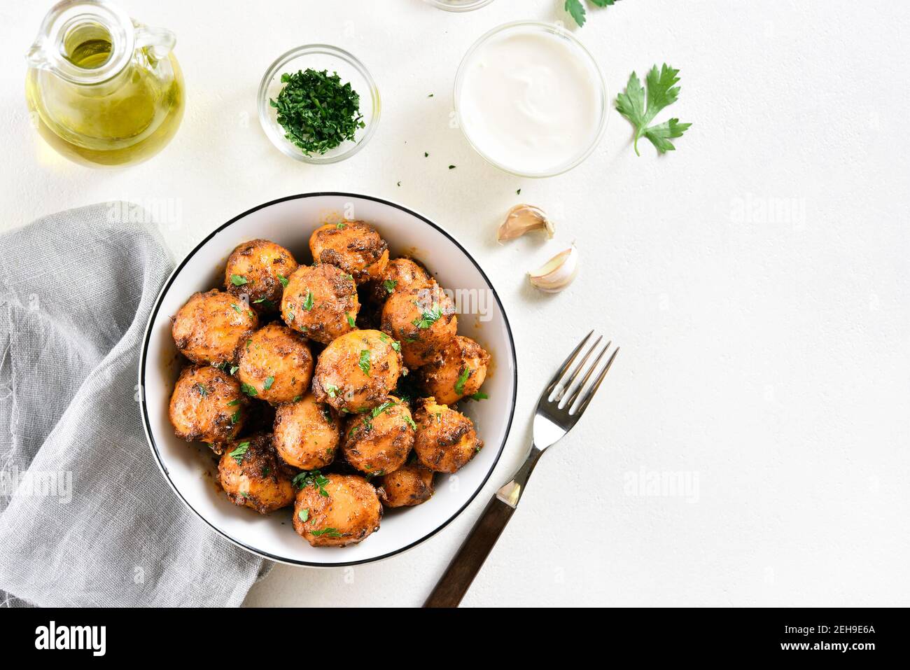 Patate Bombay. Pan patate fritte piccolo bambino con i semi di jeera e coriandolo in ciotola su sfondo chiaro con spazio libero di testo. Popolare piatto indiano. Foto Stock