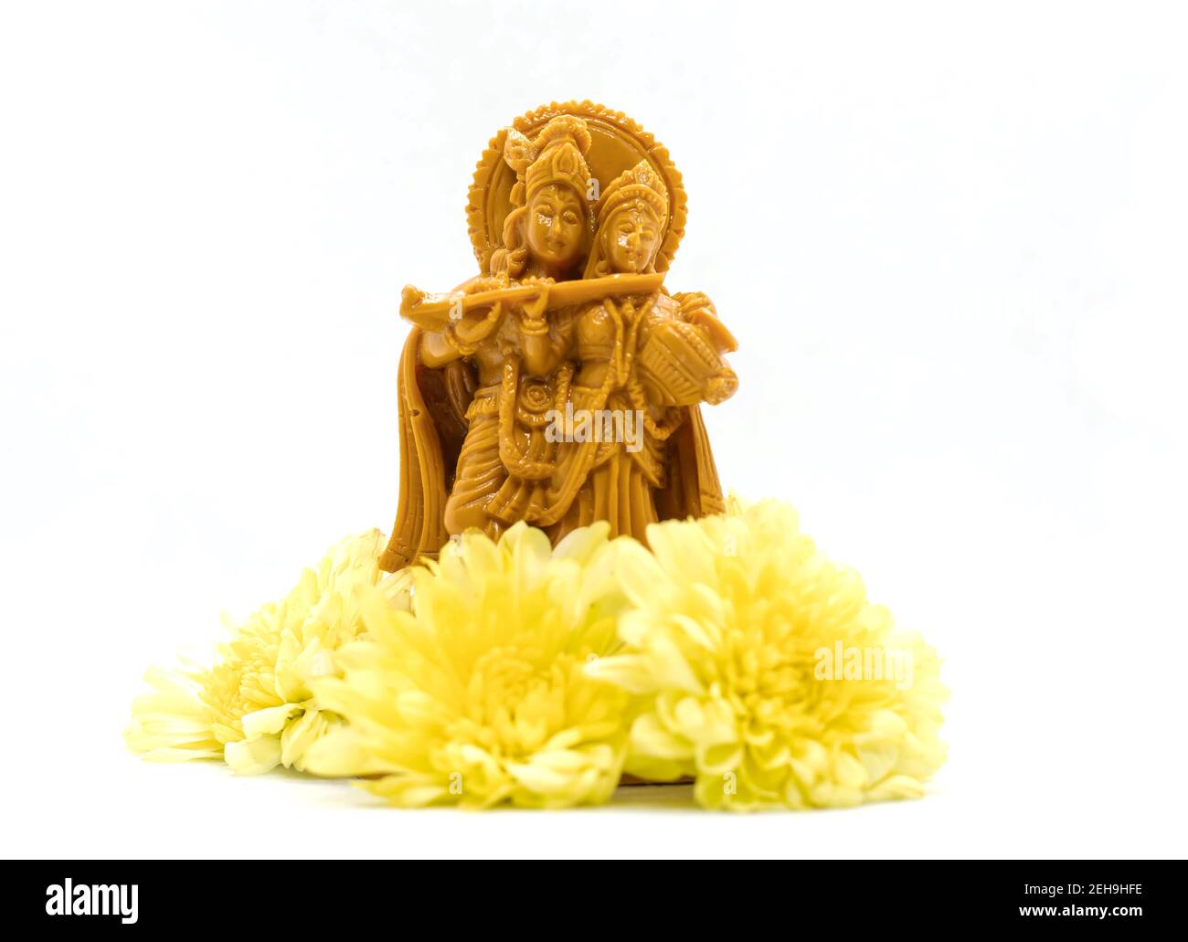 La statua di Radha Krishna con fiori è isolata uno sfondo bianco Foto Stock
