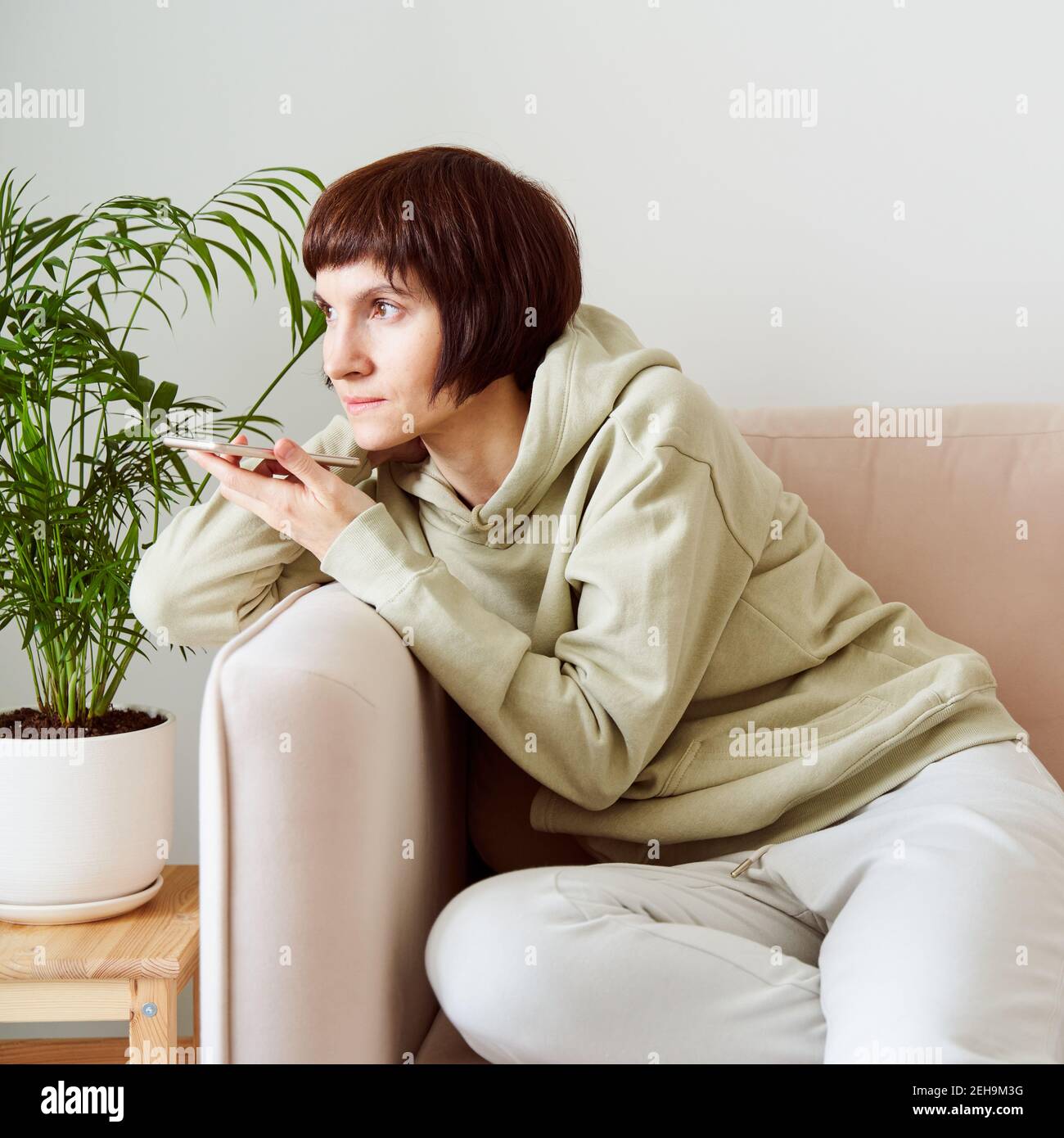 Ritratto di donna matura che registra un messaggio audio, parlando al microfono del telefono cellulare. Foto Stock