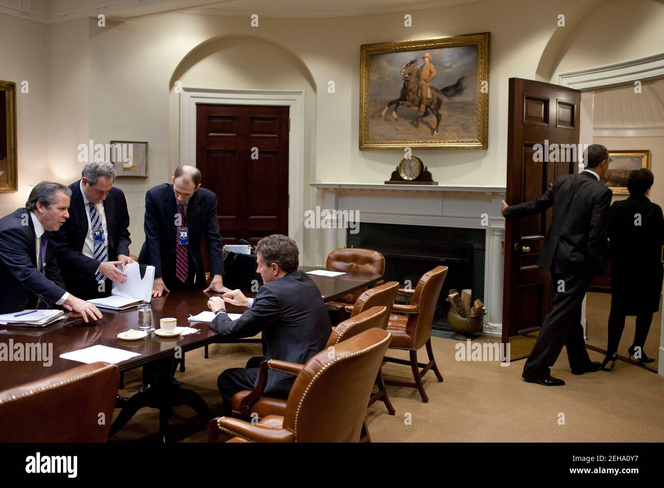 Il presidente Barack Obama e il consulente senior Valerie Jarrett partono dalla Sala Roosevelt della Casa Bianca dopo un incontro, il 24 febbraio 2011. Da sinistra, gene Sperling, direttore del Consiglio economico nazionale, Michael Foman, vice della NSA per gli affari internazionali ed economici, Austan Goolsbee, presidente del Consiglio dei consiglieri economici, e Timothy Geithner, segretario del Tesoro, continuano a lavorare. Foto Stock