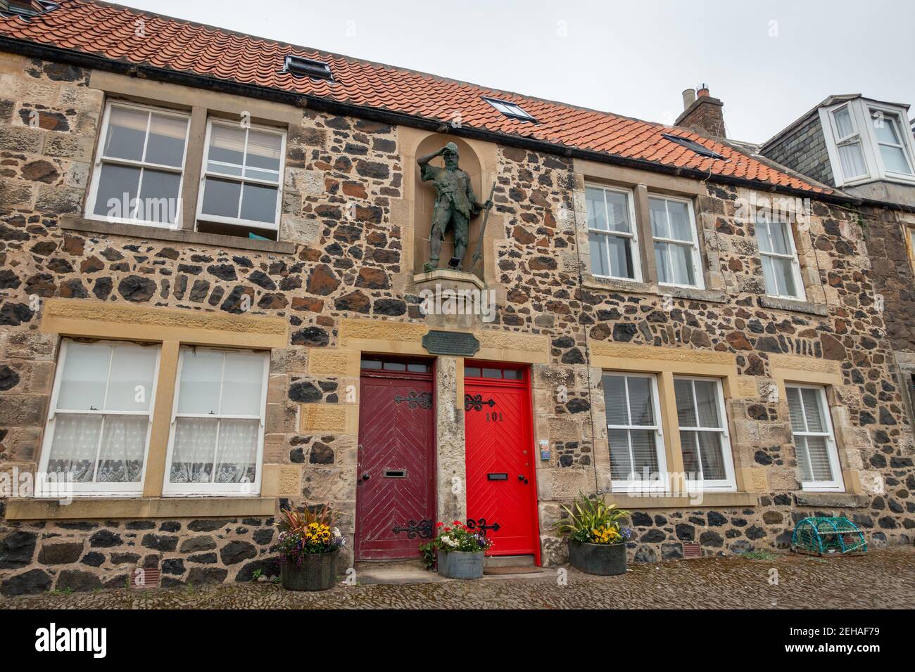 Alexander Selkir,k statua di bronzo e lapide in memoria di Selkirk fuori di una casa sul sito della sua casa originale sulla strada principale di Largo inferiore, Foto Stock