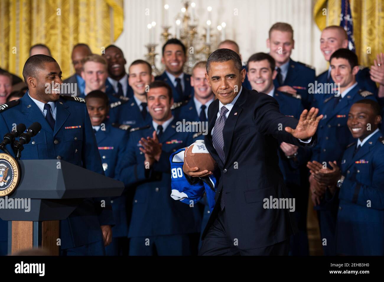 Il presidente Barack Obama colpisce la posa di Heisman dopo aver accettato un calcio dal quarterback Tim Jefferson, a sinistra, durante la presentazione del Comandante-in-Chief Trophy alla squadra di calcio dell'Accademia dell'aeronautica degli Stati Uniti nella stanza orientale della Casa Bianca, 23 aprile 2012. L'aeronautica batte l'esercito e la marina in 2011 per ottenere il trofeo per la diciottesima volta. Foto Stock