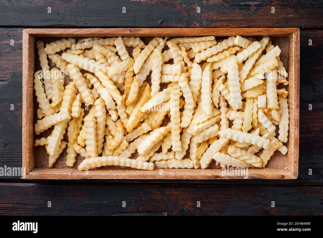 Set di patatine fritte surgelate a fette, su vassoio di legno, su sfondo  bianco Foto stock - Alamy
