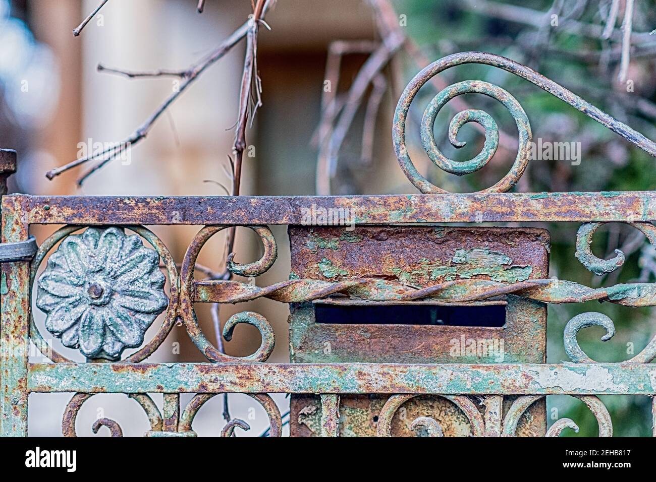 Dettaglio closeup di una recinzione in metallo arrugginito e postbox di una casa abbandonata. Foto Stock
