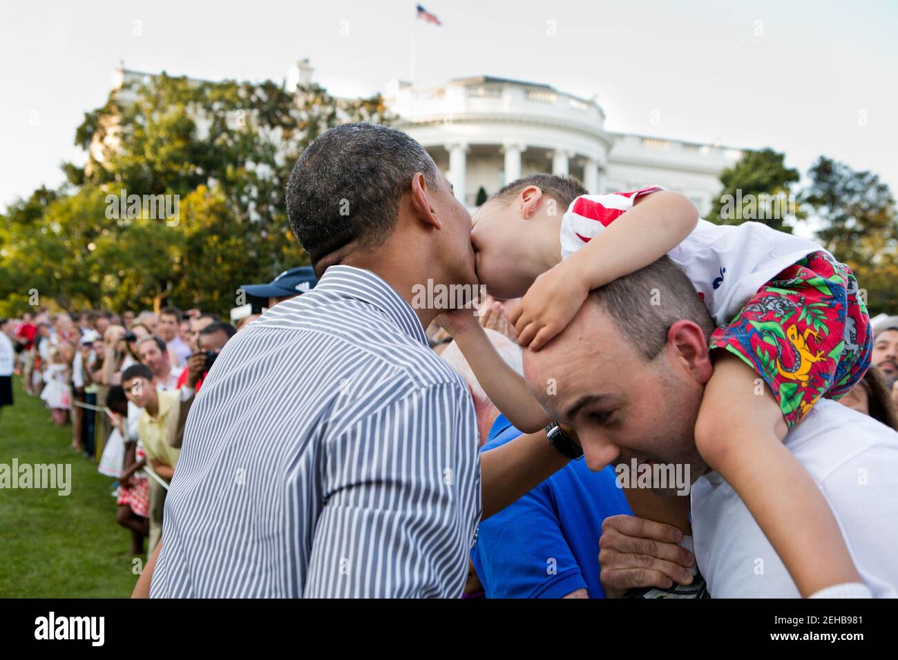 Un ragazzino si appoggia a baciare il presidente Barack Obama durante il picnic del Congresso sul prato del Sud della Casa Bianca, 27 giugno 2012. Foto Stock