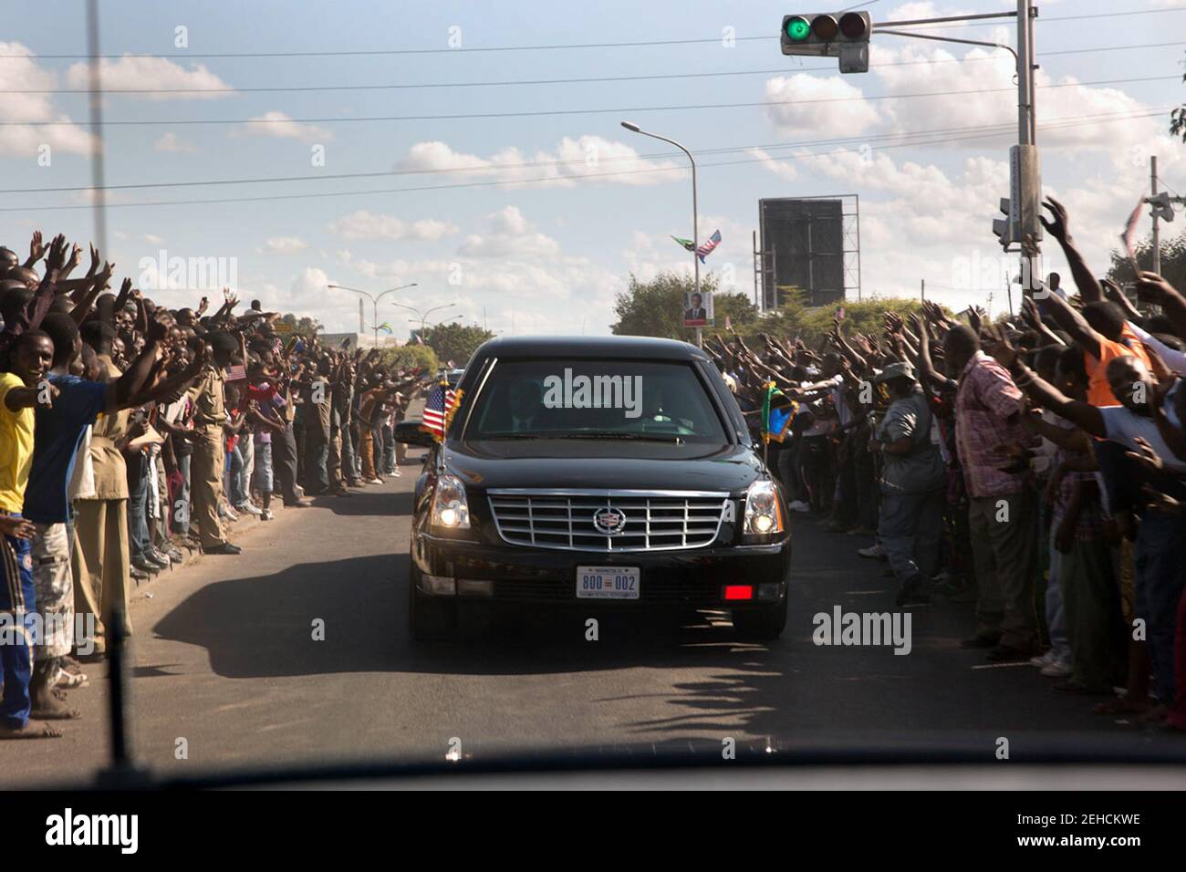 1 luglio 2013 'migliaia di persone si sono schierate per le strade mentre la motocicletta del presidente si fa strada verso la Casa di Stato di Dar es Salaam, Tanzania. Questa situazione avrebbe potuto essere pericolosa, in quanto la sicurezza locale non era in grado di tenere le persone lontano dalle automobili in accelerazione." Foto Stock