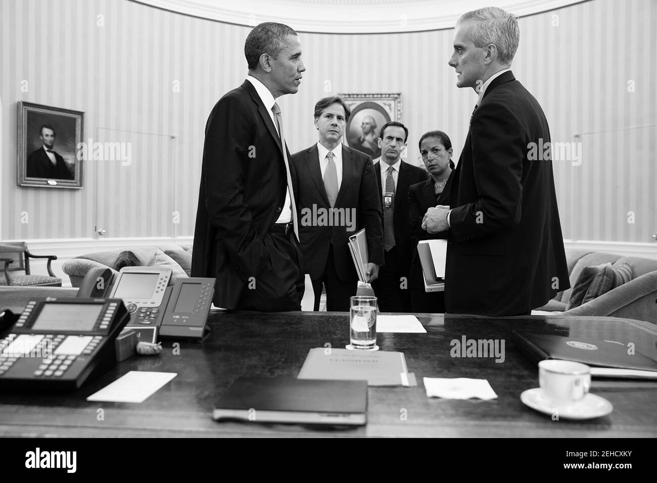 Il presidente Barack Obama parla con il capo di stato maggiore Denis McDonough e con i consulenti dell'Ufficio ovale, 10 settembre 2013. In piedi sullo sfondo, da sinistra sono: Tony Blinken, Vice Consulente Nazionale per la sicurezza; Phil Gordon, Coordinatore della Casa Bianca per il Medio Oriente, Nord Africa e la Regione del Golfo; e il Consulente Nazionale per la sicurezza Susan E. Rice. Foto Stock