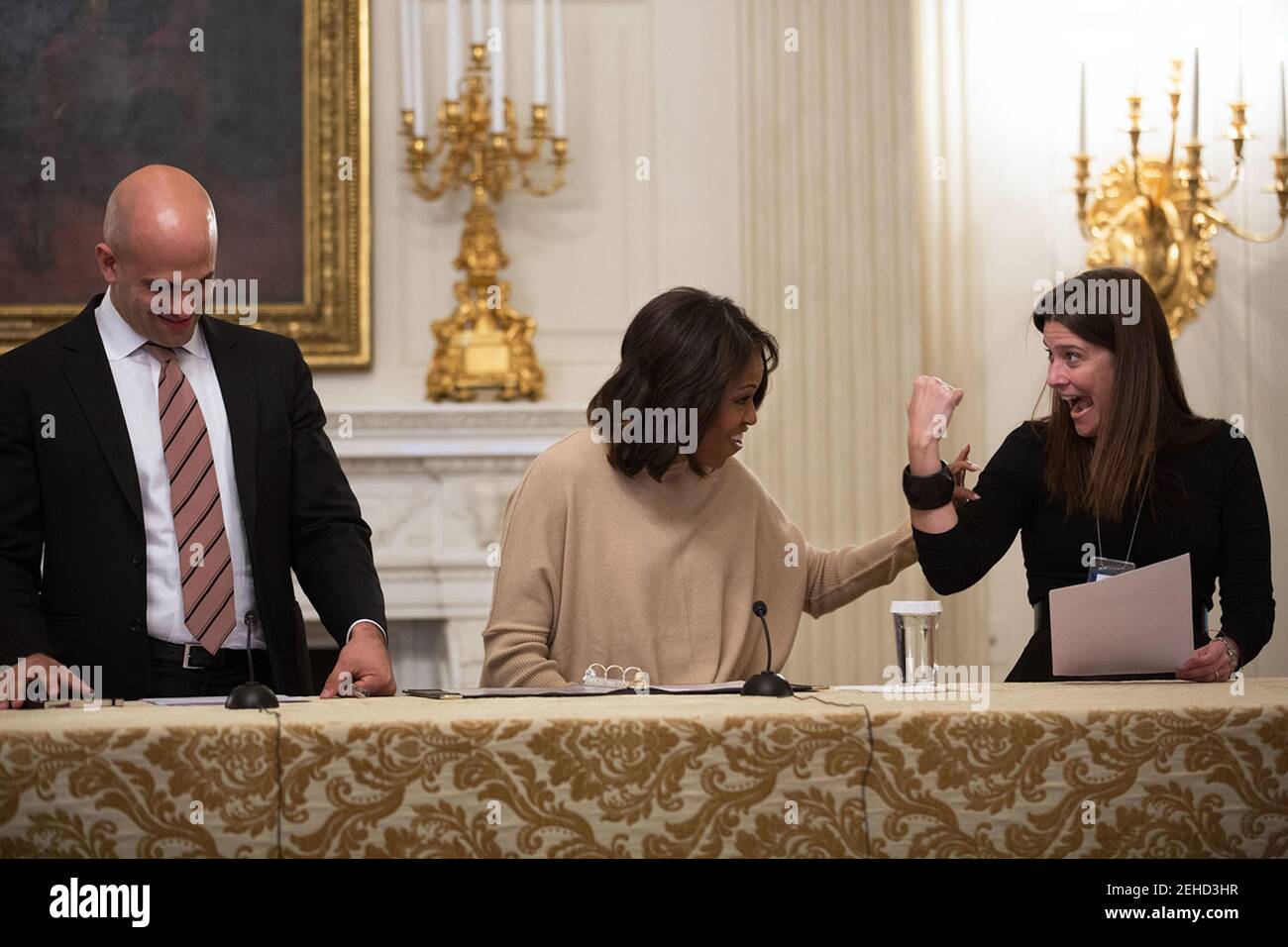 First Lady Michelle Obama preps per un annuncio di Sesame Street sulla commercializzazione di alimenti più sani per i bambini, con Sam Kass, Direttore Esecutivo di 'Let's Move!', e Maria Cristina 'MC' Gonzalez Noguera, Direttore delle Comunicazioni per la First Lady, nella Sala da pranzo di Stato della Casa Bianca, 28 ottobre 2013. Foto Stock