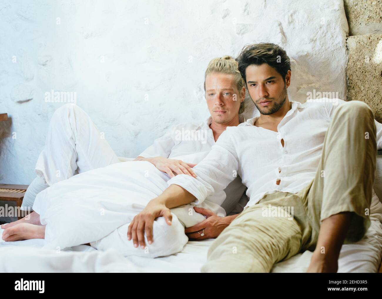 Due uomini seduti sul letto che si guardano via Foto Stock
