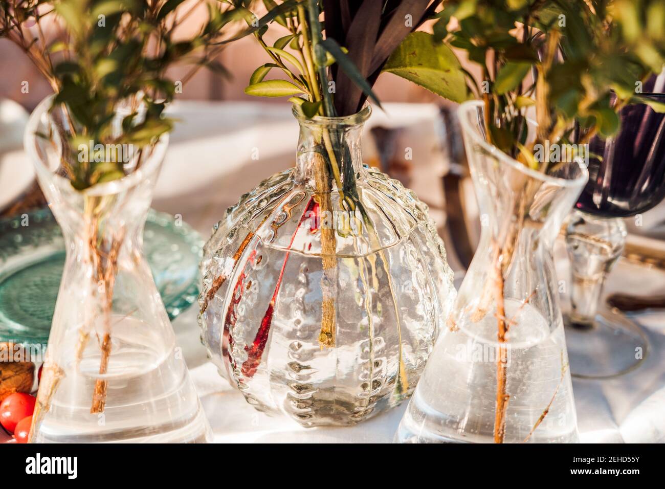 Alto angolo di vasi di vetro trasparente con mazzi di fresco fiori posti sul tavolo per l'evento Foto Stock
