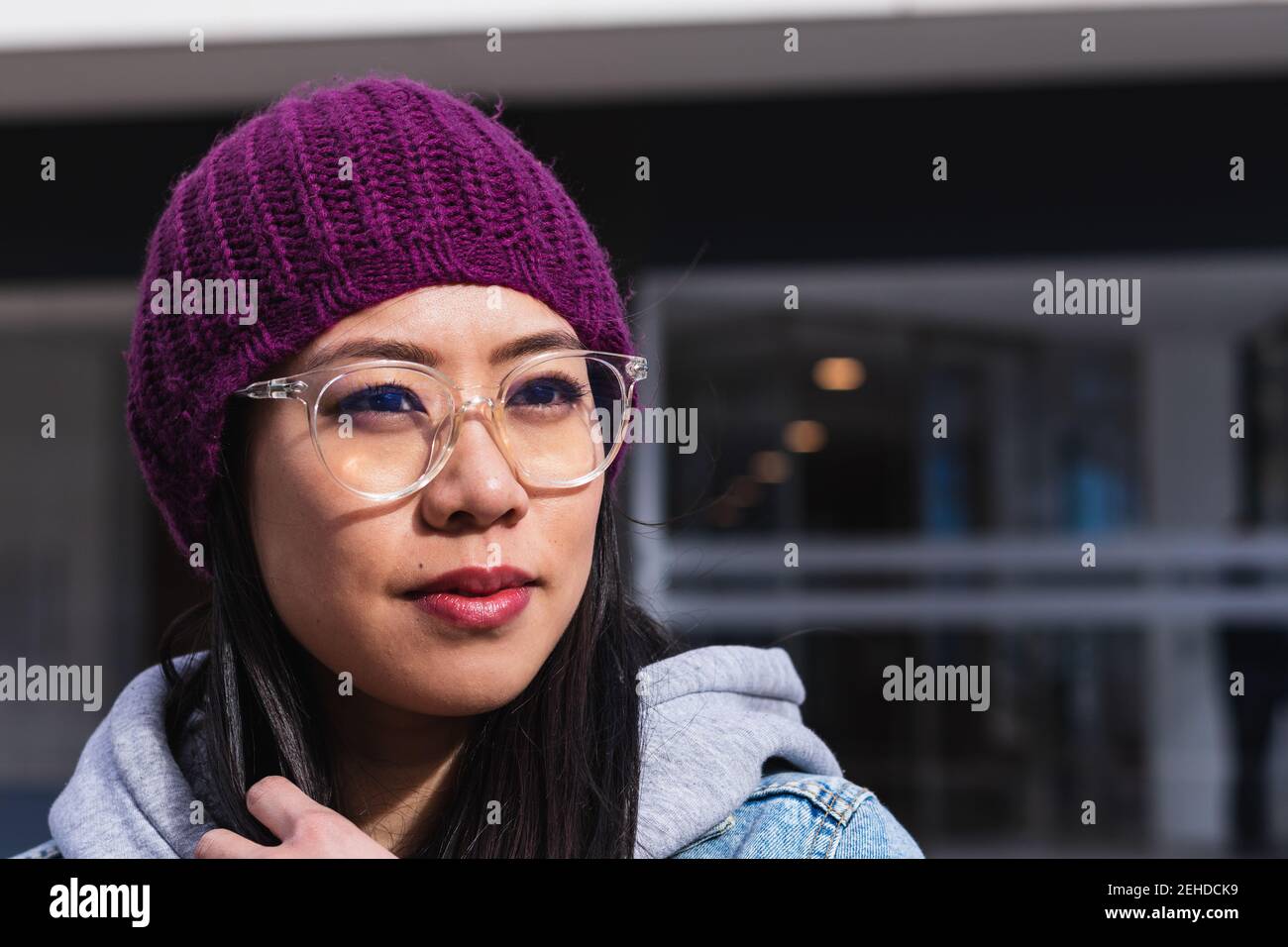 Ritratto di una donna asiatica con un cappello viola per strada Foto Stock