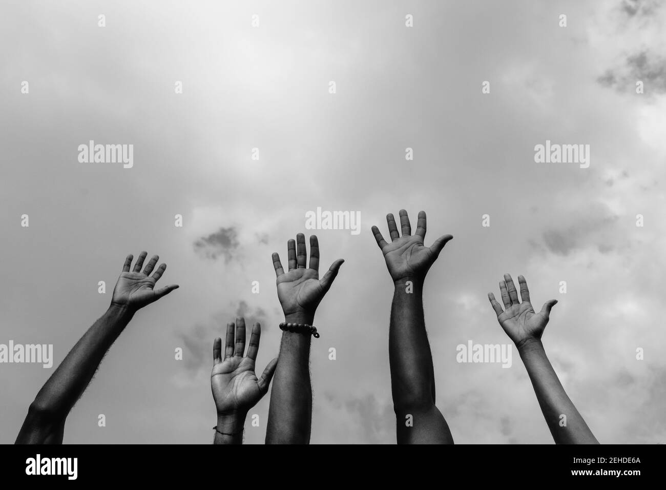 Dal basso di raccolto anonimi africani americani guerrieri della giustizia sociale sollevare armi bianche lotta per i diritti sociali durante la manifestazione Foto Stock