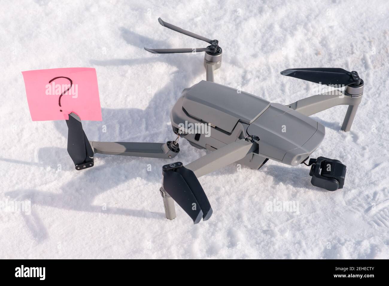 Nota appiccicosa con punto interrogativo sulle pale dell'elica di rotto drone sulla neve Foto Stock