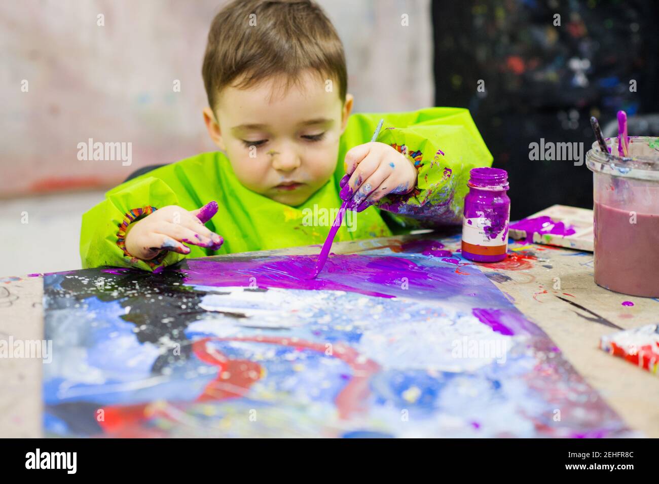 Toddler che applica la vernice di gouache con il pennello durante l'attività di arte Foto Stock