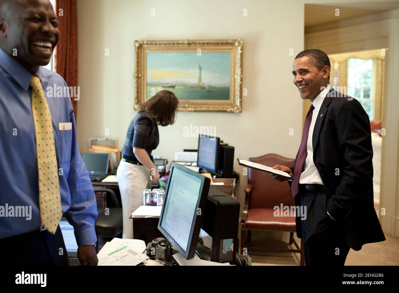 Il presidente Barack Obama e l'Aide Reggie Love personale, Aide personale al presidente, condividono una risata fuori dell'Ufficio ovale nella Casa Bianca, 24 giugno 2009. Cener è segretaria personale Katie Johnson. Foto Stock