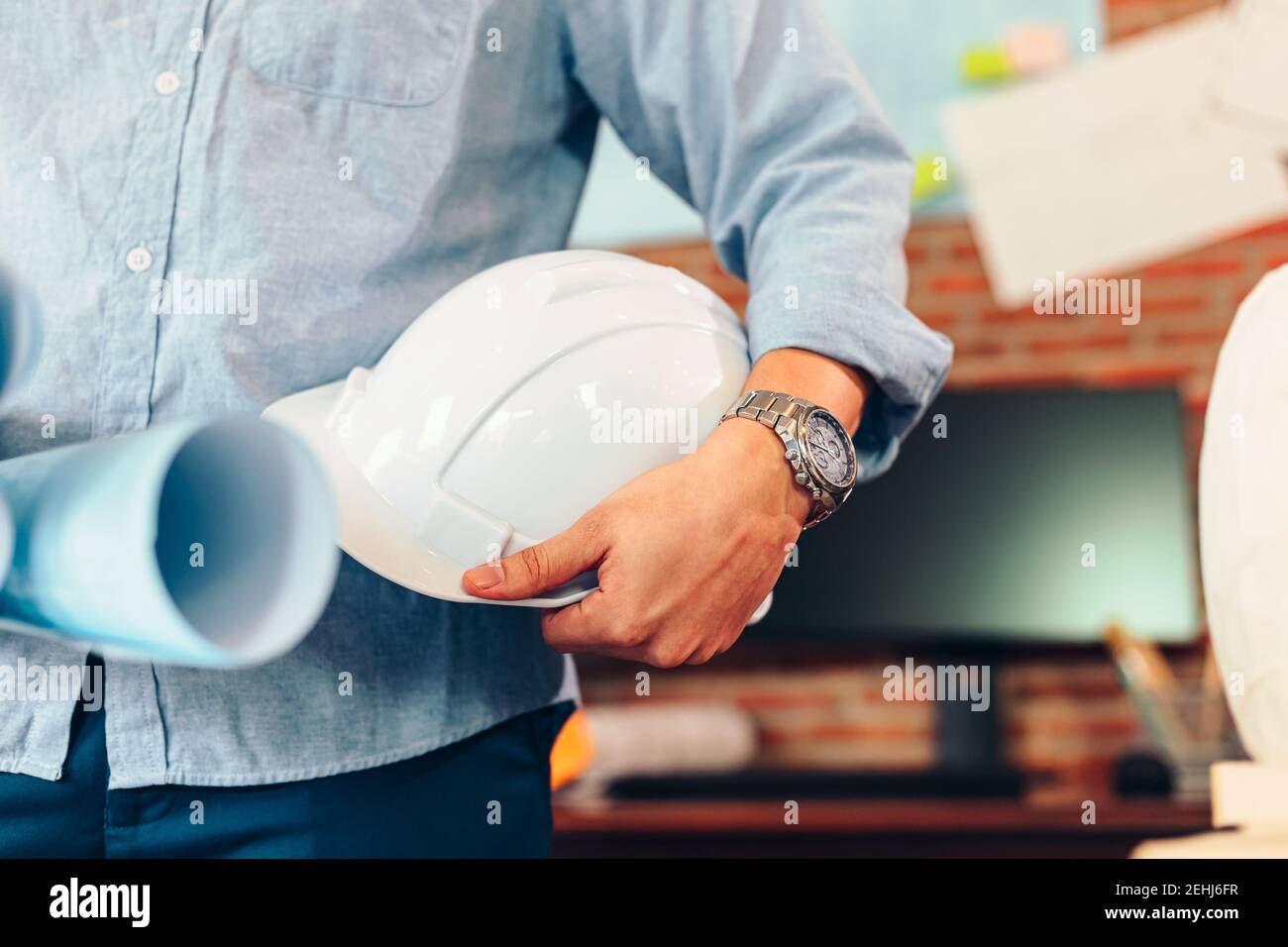 ingegnere tenere ingegnere disegno progetti di progettazione e casco di sicurezza in sala nella costruzione del sito. Foto Stock