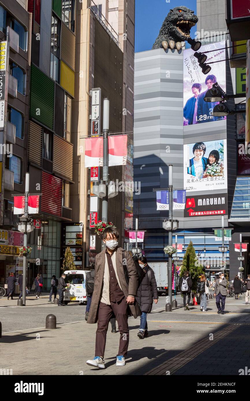 Tokyo, Giappone. 03 Feb 2021. Un uomo che indossa un facemask come misura preventiva contro Covid19 cammina nel quartiere di Kabukicho con un grande modello Godzilla sul retro dell'Hotel Gracery. Il primo ministro giapponese, Yoshihide Suga ha dichiarato un secondo stato di emergenza per Tokyo l'8 gennaio che ha chiesto alle imprese di chiudere a partire dalle 20 per combattere un aumento delle infezioni da coronavirus. Credit: SOPA Images Limited/Alamy Live News Foto Stock