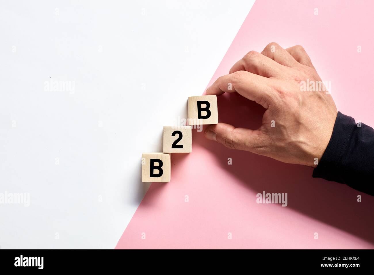 Mano maschile disposizione dei cubi di legno con l'acronimo B2B business to business. Business transaction e concetto di partnership aziendale. Foto Stock