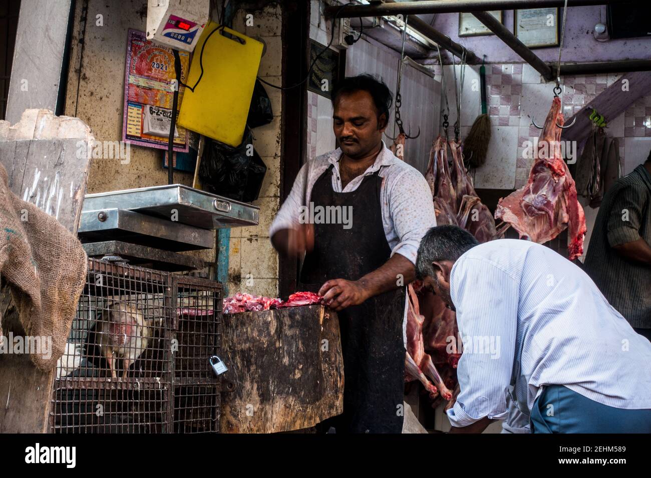 Macellaio indiano a Chennai a lavorare tagliando carni in aperto Foto Stock