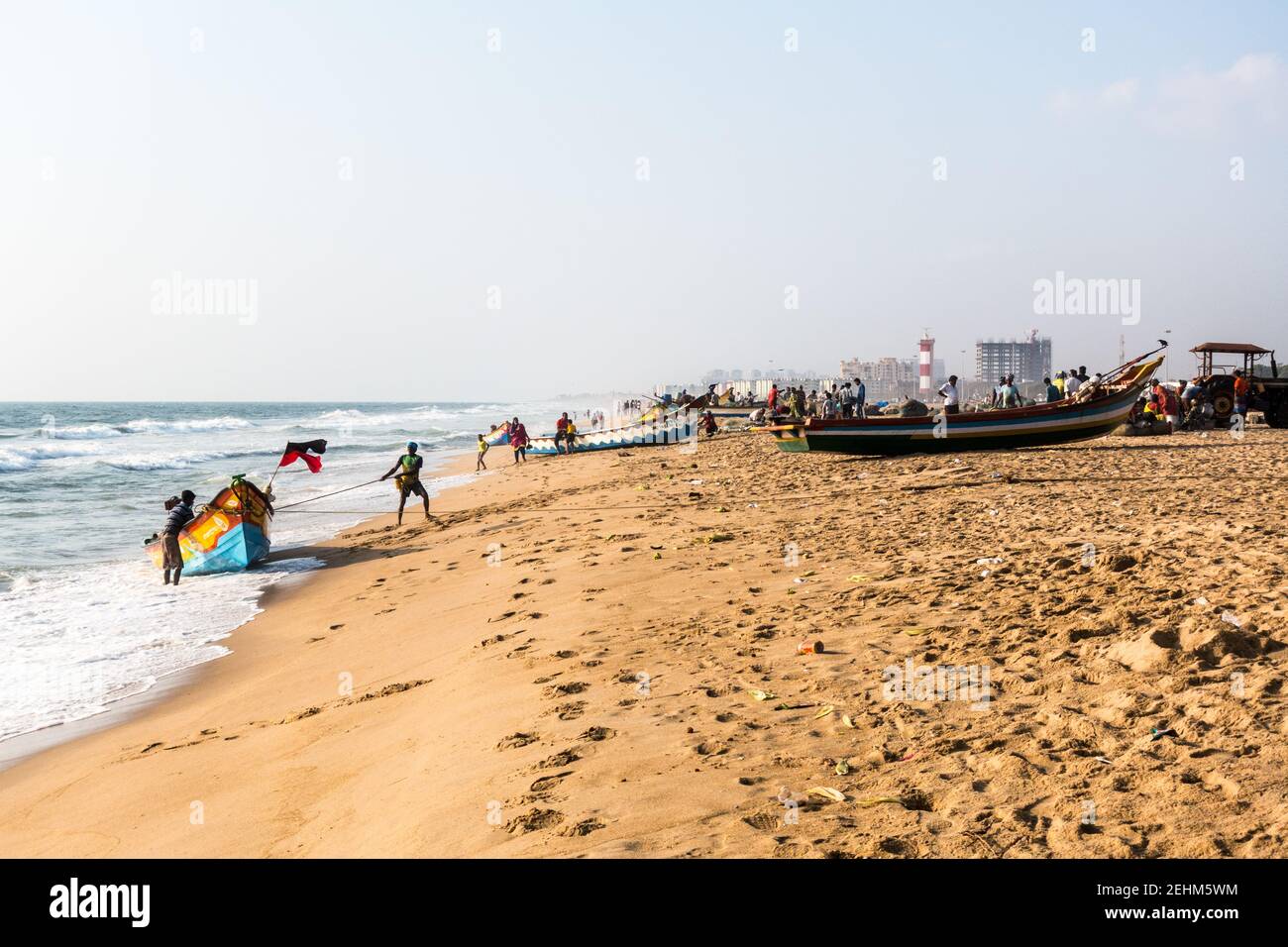 Pescatore che spinge la barca a terra dal mare dopo il ritorno il lavoro di giorno Foto Stock
