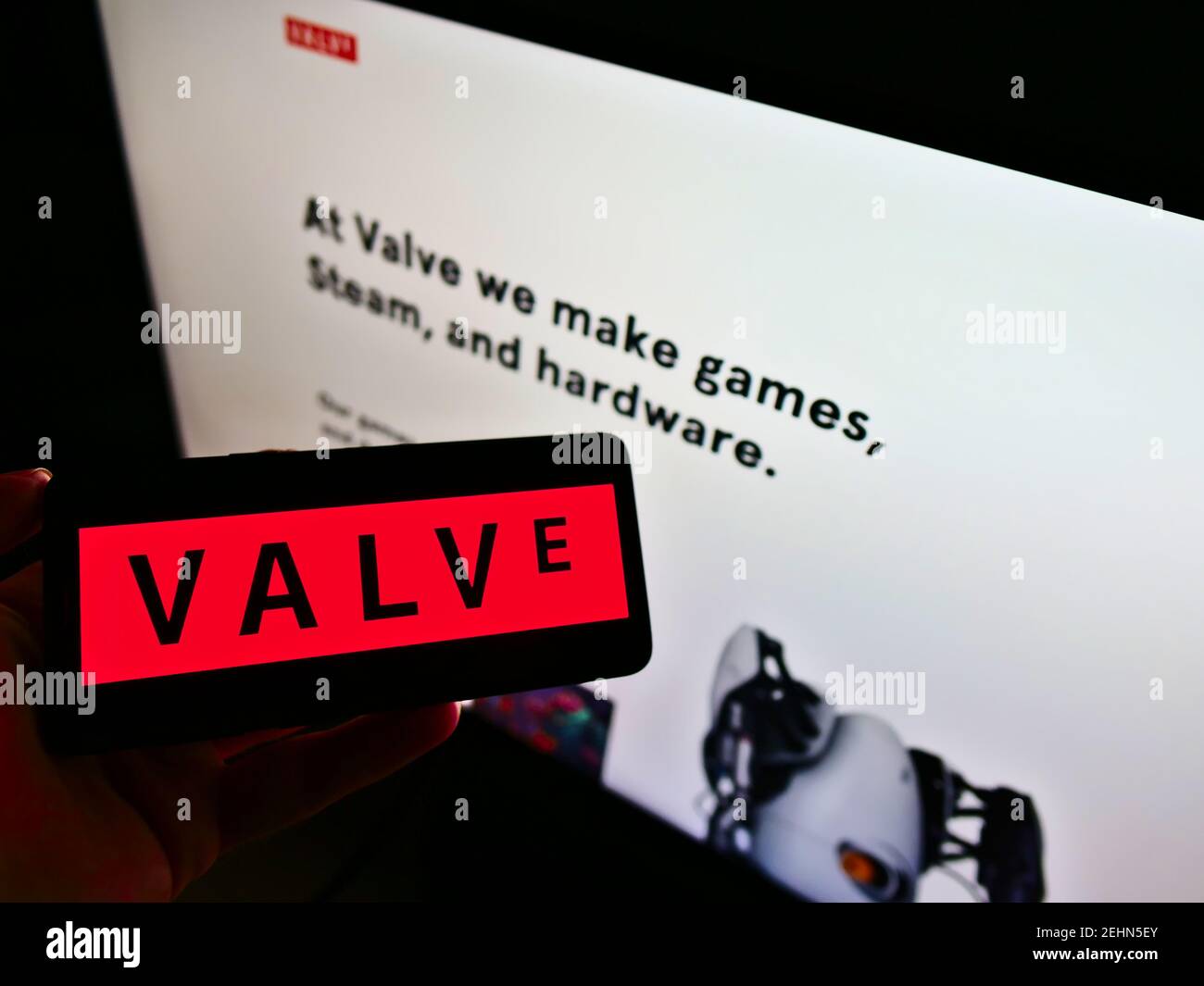 Persona che tiene lo smartphone con il logo della società americana di videogiochi Valve Corporation sullo schermo davanti alla pagina web aziendale. Mettere a fuoco il display del telefono. Foto Stock