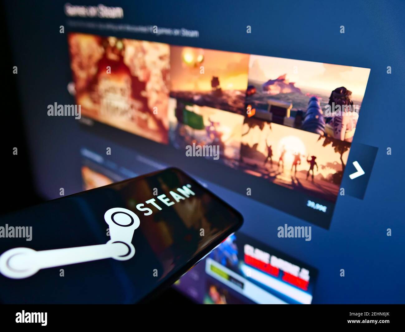 Cellulare con logo della piattaforma di distribuzione di videogiochi Steam gestito da Valve sullo schermo davanti alla pagina web. Mettere a fuoco il centro del display del telefono. Foto Stock