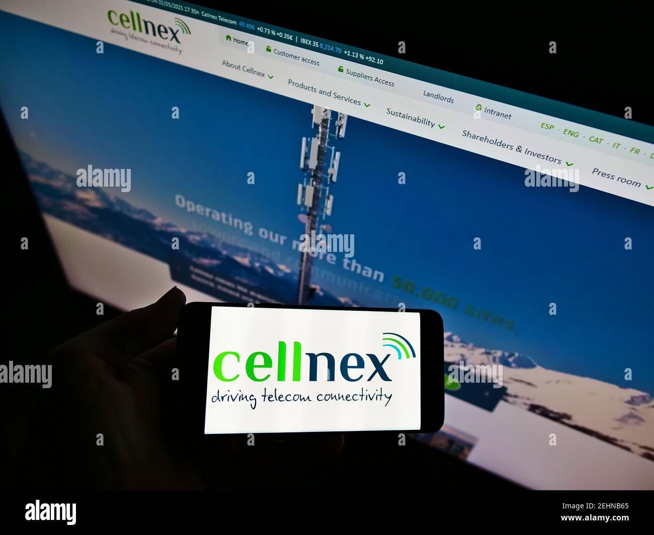 Persona che detiene cellulare con logo della società spagnola di telecomunicazioni Cellnex Telecom SA sullo schermo di fronte alla pagina web. Mettere a fuoco il display del telefono. Foto Stock