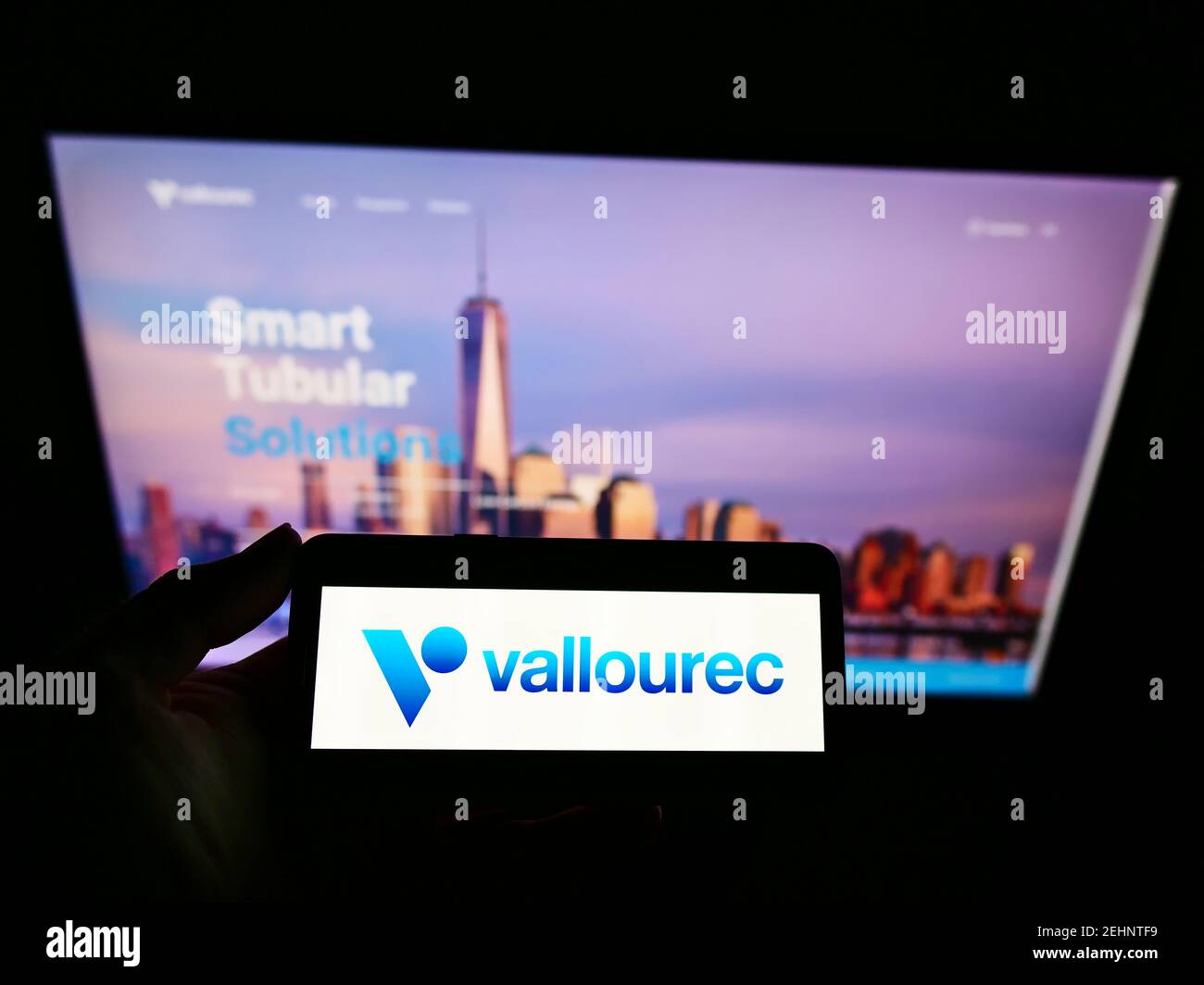 Persona che detiene smartphone con logo del produttore francese di tubi d'acciaio Vallourec S.A. sullo schermo davanti al sito web. Mettere a fuoco il display del telefono. Foto Stock