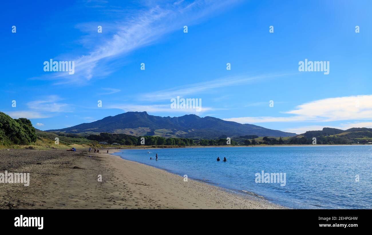 Te Kopua Beach, un lungo tratto di sabbia nera a Raglan, Nuova Zelanda. All'orizzonte si trova il Monte Karioi Foto Stock