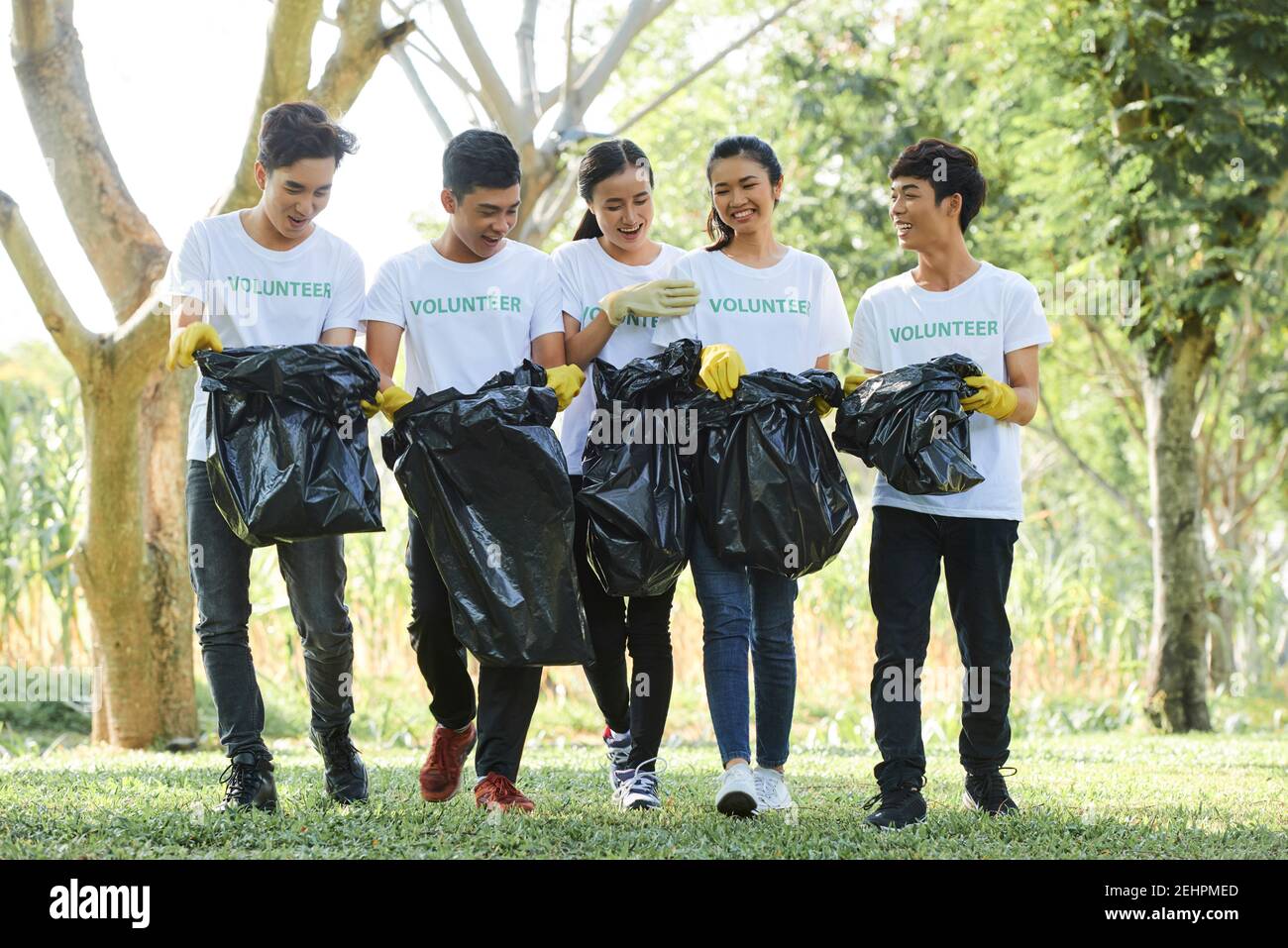 Volontari che trasportano sacchetti di spazzatura Foto Stock